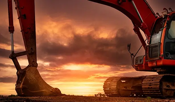 heavy machinery excavator against a sunset background